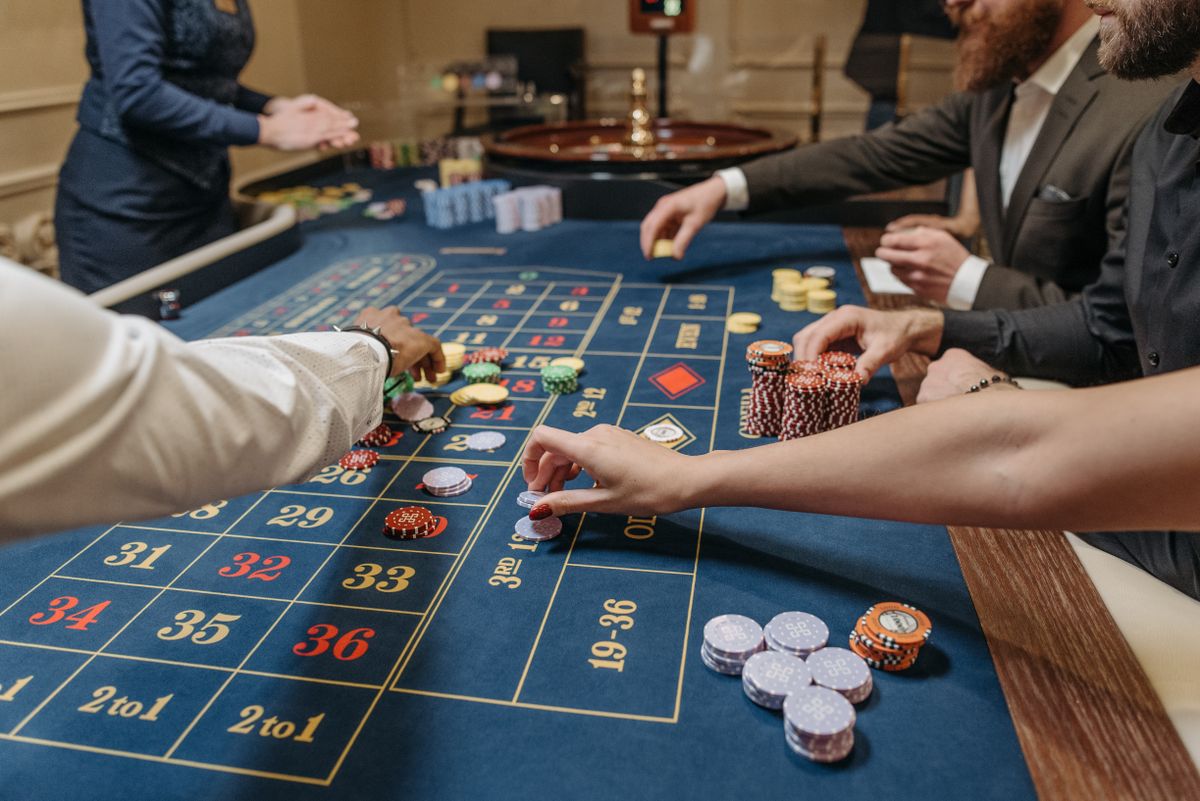 Meja roulette dengan dealer dan pemain di live casino