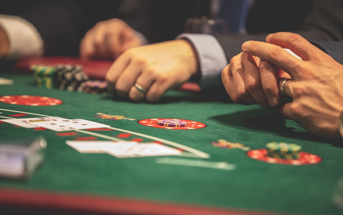 Kartu remi dan chip poker di atas meja hijau