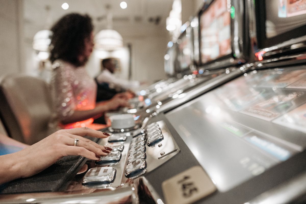 Tangan pemain menekan tombol mesin slot online
